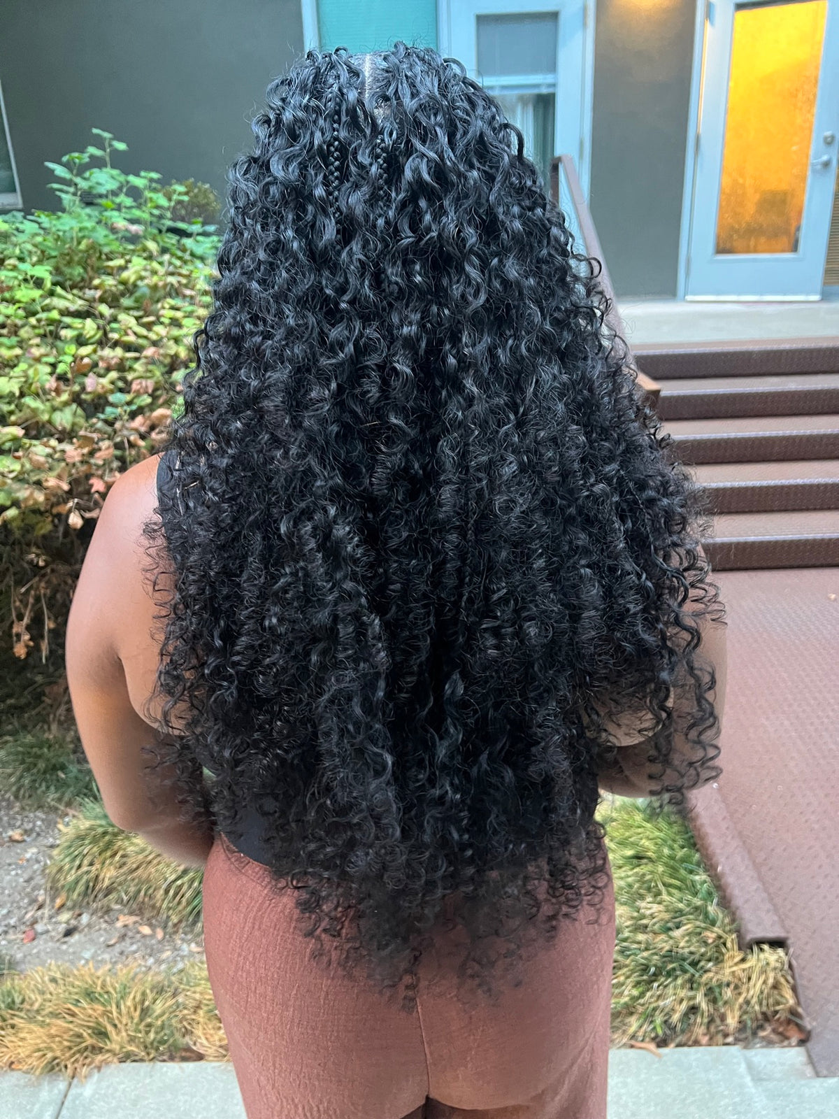 Burmese curly crochet worn on medium braids, back view
