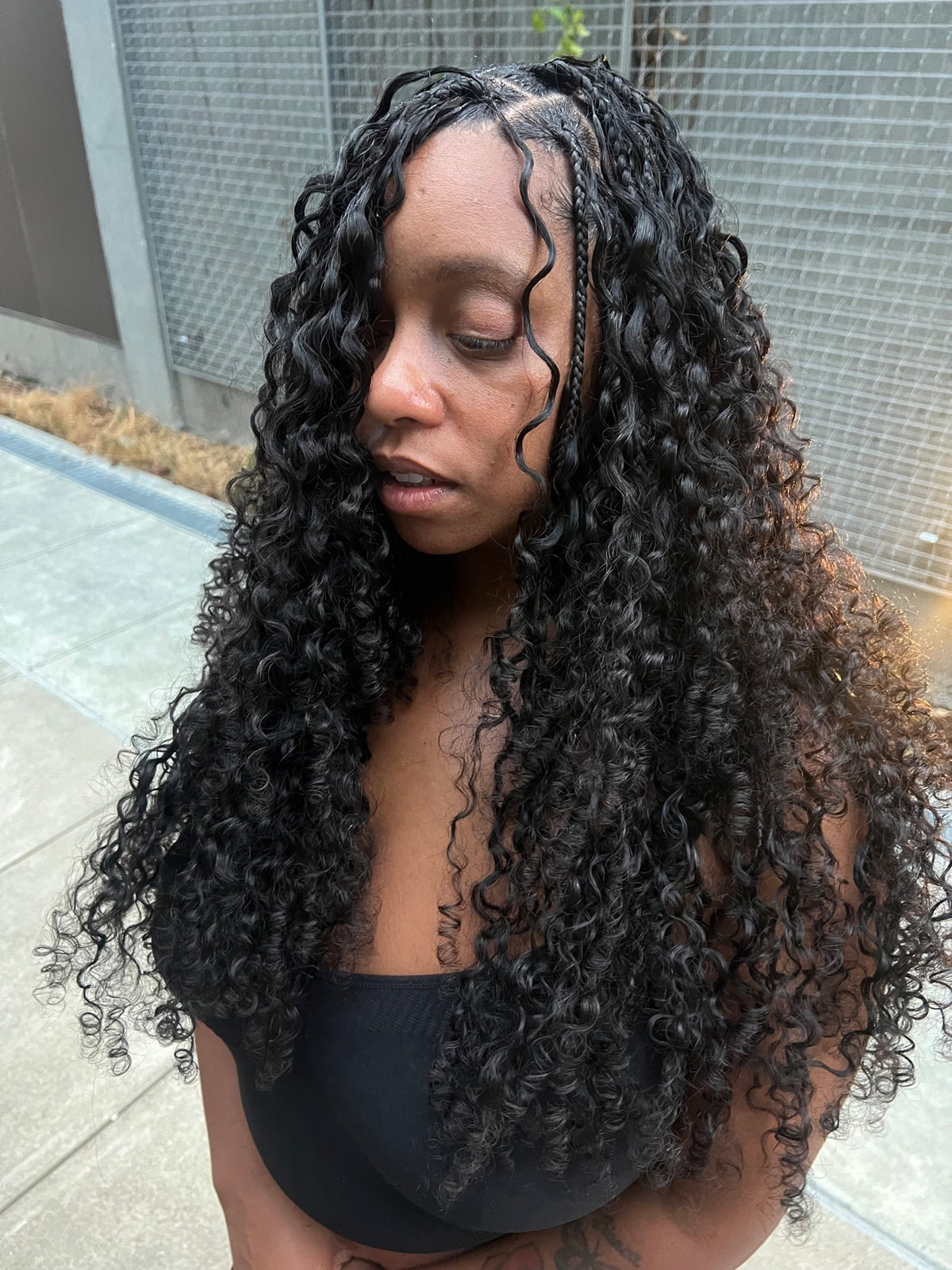 Burmese curly crochet worn on medium braids, front view